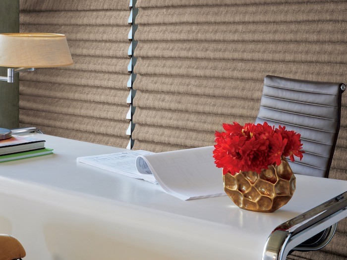 Desk and chair with tan Roman shades.